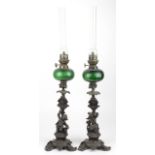 Pair of figural oil lamps, circa late 19th to early 20th Century, with green glass reservoirs, clear