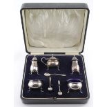 Boxed five piece silver cruet set, three silver spoons and three blue glass liners. All silver items