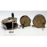 Three early 20th Century fishing reels, two in brass, the other brass & nickel