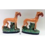 Pair of Victorian Staffordshire pottery figures modelled as a greyhound with rabbit in its mouth,