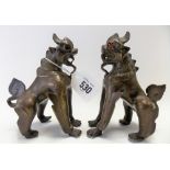 Pair of oriental bronze mythical creatures with glass inset eyes, height 15cm.