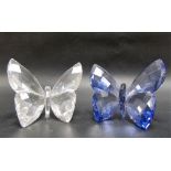 Two Swarovski crystal butterflies, one in amethyst colour, the other clear within box.