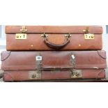 Two vintage tan leather suitcases.