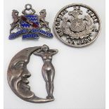 Early 20th Century white metal badge cast as the man on the moon & a nude female; together with a