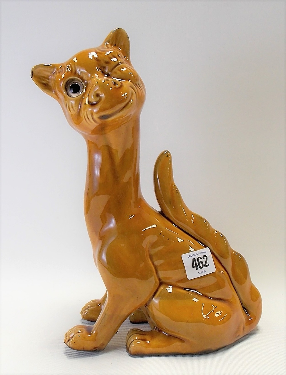 Watcombe Torquay pottery model of a stylised seated winking cat with glass inset eye, stamp mark