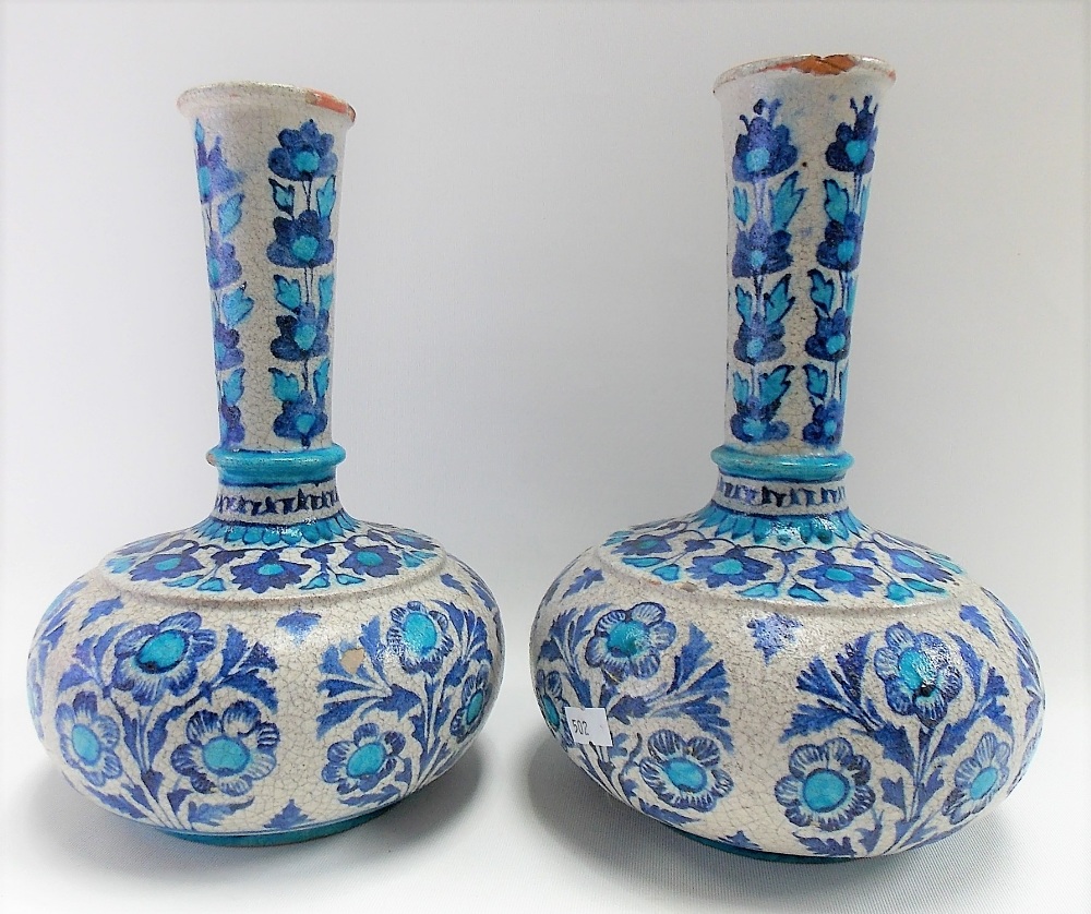 Pair of Iznik bottle vases painted in blue and turquoise with stylised flowers, height 26cm.