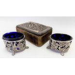 Pair of Victorian silver foliate C scroll embossed and pierced oval salts with blue glass liners,