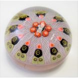 A Strathern Glass paperweight with pink, black & yellow canes divided by white latticino twists,