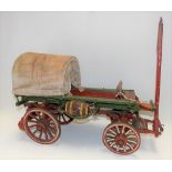 Painted wooden model of a prairie cart, length 86cm.