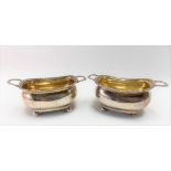 Pair of George III silver salts of oval section with gadrooned rims & raised on four ball feet,