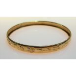 Yellow metal foliate engraved bangle, weight 6.4g approx.