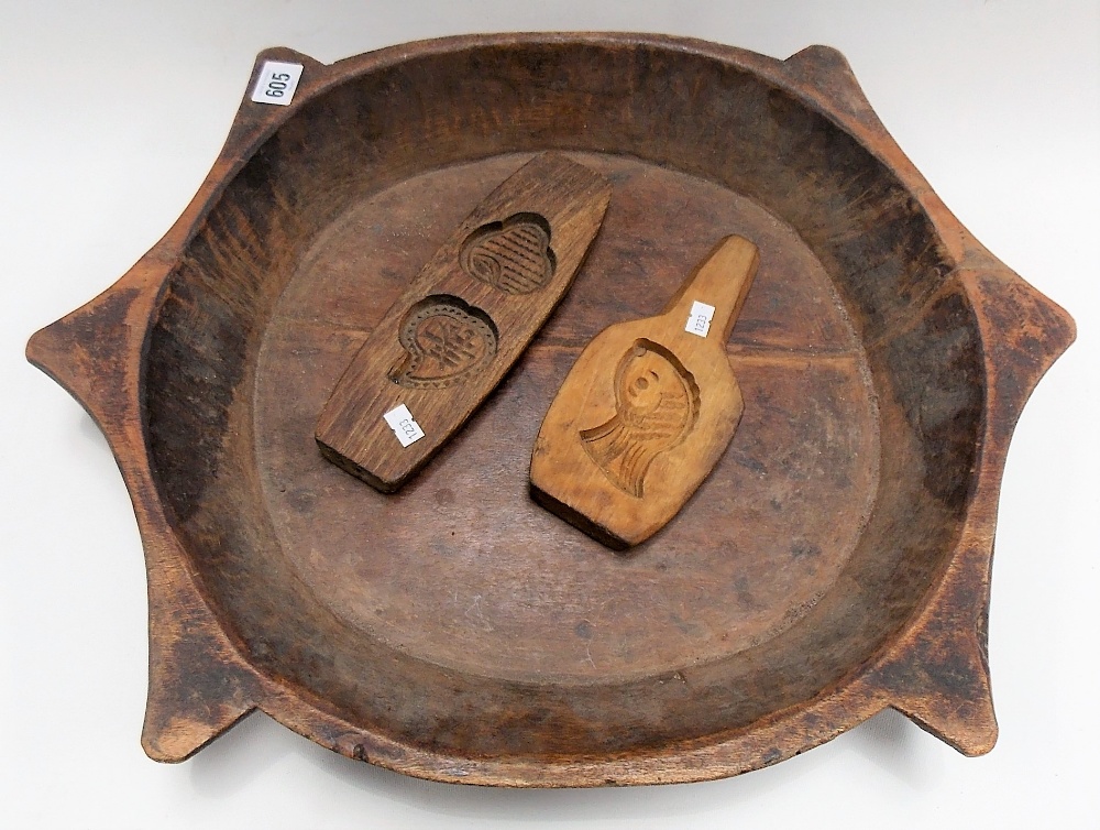 Two carved wood butter pats together with a large circular carved wood bowl