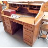 Early 20th Century oak tambour front roll-top desk enclosing pigeonholes & two short drawers, the