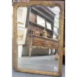 18th Century bevel edged gilt framed wall mirror, the mirror with shaped top, the frame gilt gesso