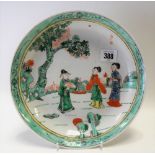 Chinese famille verte dish, painted with three figures within a garden, painted with seal mark to