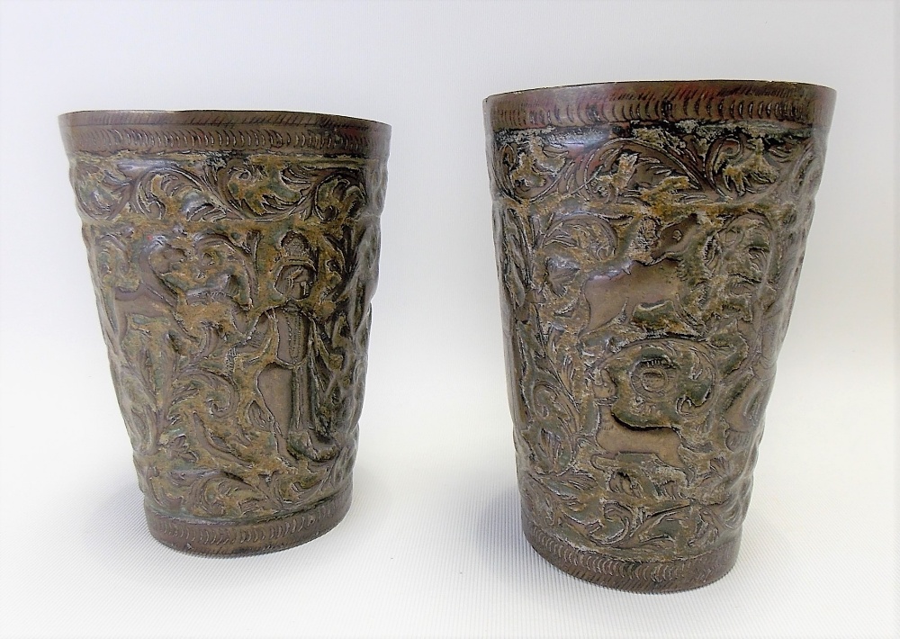 Pair of Indian enamel on copper embossed cups decorated with three figures, hounds & deer amongst