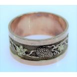 Yellow metal bi-colour band ring, cast and engraved with fruiting vine, weight 6.4g approx.