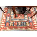 A Kazak hand-knotted rug, with bold geometric motifs within borders upon a cream ground, 175cm x