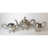 Chinese white metal three piece tea set, each with bamboo cast handles and four outswept feet, the