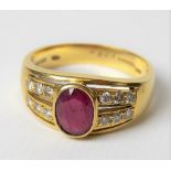 Modern 18ct gold ruby and diamond set ring, the oval cut ruby in collet setting of 0.75ct spread