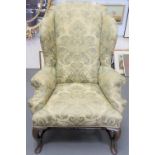 A 19th Century George I style wing back armchair with scrolling arms