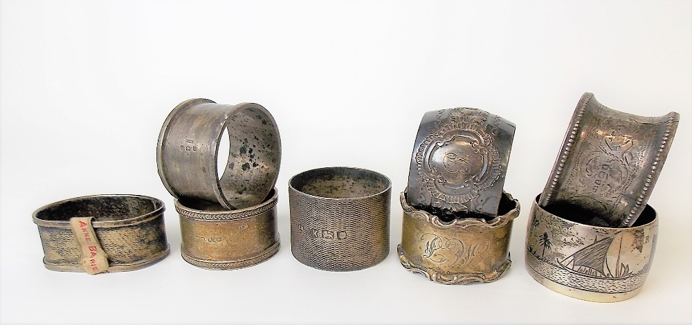 Seven various silver hallmarked napkin rings; together with a white metal Niello napkin ring, weight