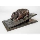 Bronze paperclip, the clip cast as a reclining bear upon a rectangular base, length 11cm.