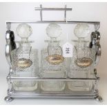 Early 20th Century silver plated three section Tantalus with cut glass whisky decanters and