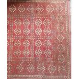 Middle Eastern rug with two rows of six squares within a square border, upon a red ground, width