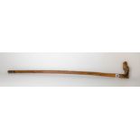 Carved wood walking cane, the handle carved as a horse head & saddle, the back with a tablet