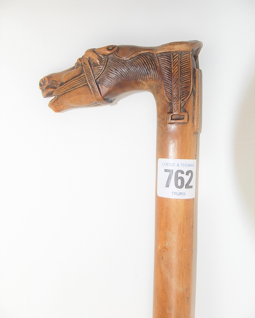 Carved wood walking cane, the handle carved as a horse head & saddle, the back with a tablet - Image 2 of 4