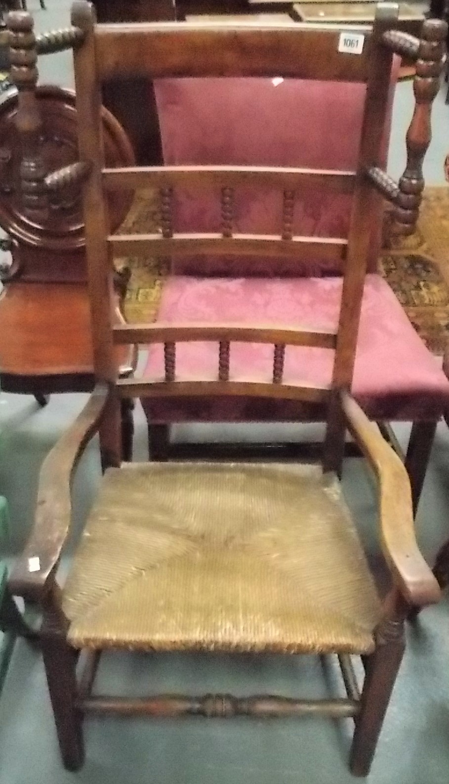 A Lancashire rush seat ladderback elbow chair with bobbin turned side head rails