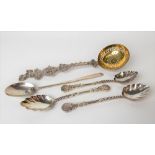 Continental white metal sifter spoon with ornate cast and pierced handle; together with three