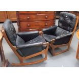Pair of Mid Century Danish teak black leather upholstered armchairs, one a rocker