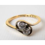 Gold and diamond two stone cross over ring, the collet set diamonds of 0.10ct spread approx,