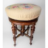 Victorian walnut circular section adjustable piano stool raised on four turned supports
