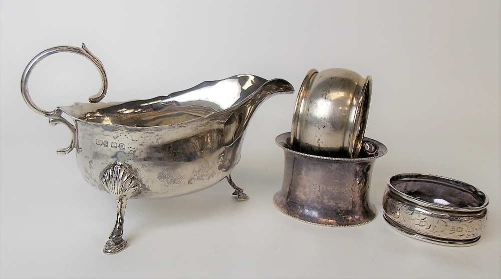 George V silver sauceboat with flying scroll handle and raised on triple outswept feet, Birmingham