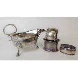George V silver sauceboat with flying scroll handle and raised on triple outswept feet, Birmingham