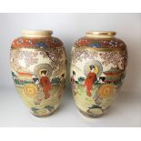 Pair of Japanese satsuma vases decorated with figures within a pagoda landscape, height 31cm