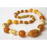 Chinese amber and bone bead necklace, the central oval carved bead width 2.5cm and with twenty