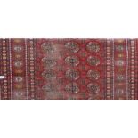 Middle Eastern rug with three rows of twelve medallions and within geometric borders upon a red