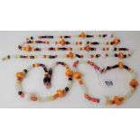 Three unusual amber, glass and hardstone bead necklaces, of varying lengths, longest 118cm, 41cm &