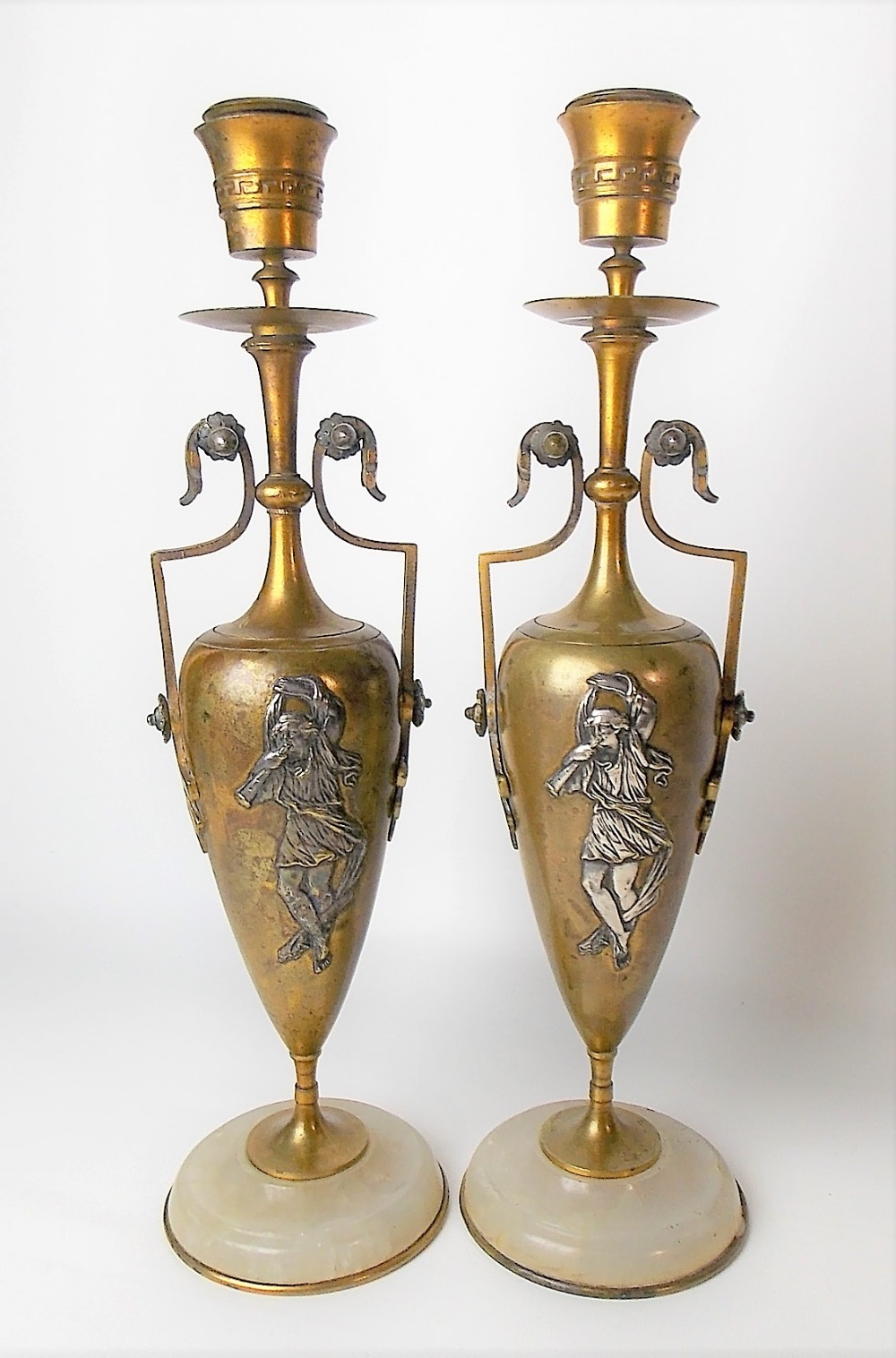 Pair of gilt lacquered bronze and silvered twin handled urn candlesticks with a circular onyx