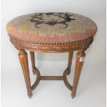 Oval stool with woolwork tapestry upholstered seat over a carved frieze & turned tapering legs