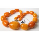 Butterscotch amber graduated bead necklace with nineteen oval graduated beads with screw clasps, the