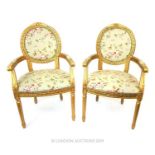 A pair of Louis XVI style gilt framed upholstered elbow chairs.