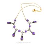 A necklace set with diamonds and polished cabochon amethysts.