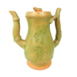 A tall green glazed oriental tea pot decorated with bamboo, seal marks to base