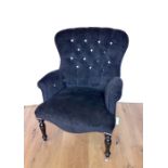 A Black Upholstered Button Back Armchair.