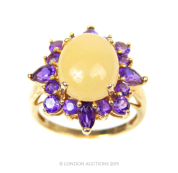 A 14 Carat Gold Oval Claw Cabochon White Jade with Halo of Amethyst Ring.